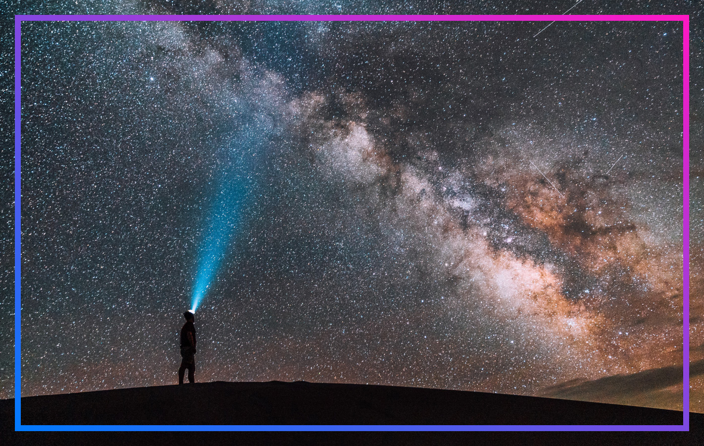 Person mit Stirnlampe schaut in den Nachthimmel voller Sterne. Sinnbild für das Erforschen des Weltalls.